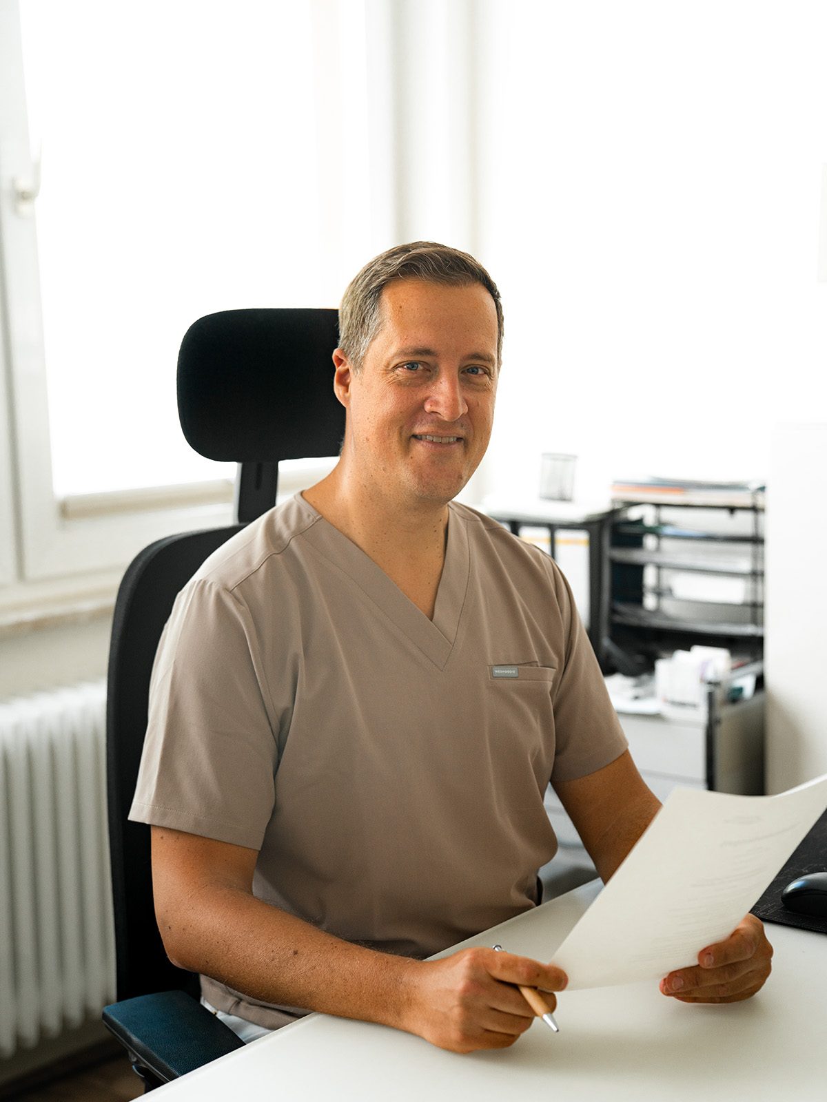 Jochen Wolf, Facharzt für Allgemeinmedizin, im Sprechzimmer der Hausarztpraxis Jochen Wolf am Schillerplatz in Mainz