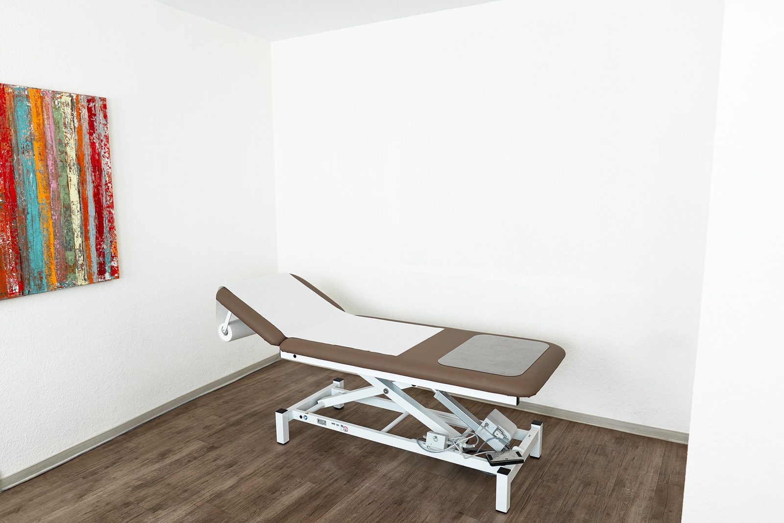 Behandlungszimmer mit höhenverstellbarer Untersuchungsliege in der Praxis Jochen Wolf & Kollegen, Mainz